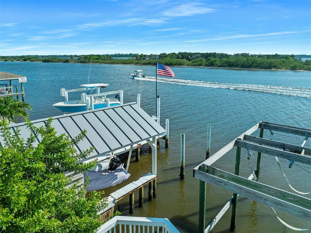 An aerial view shows a light green house with a pool, deck, and boat dock — 3110 JOHN ANDERSON DRIVE, ORMOND BEACH, FL
