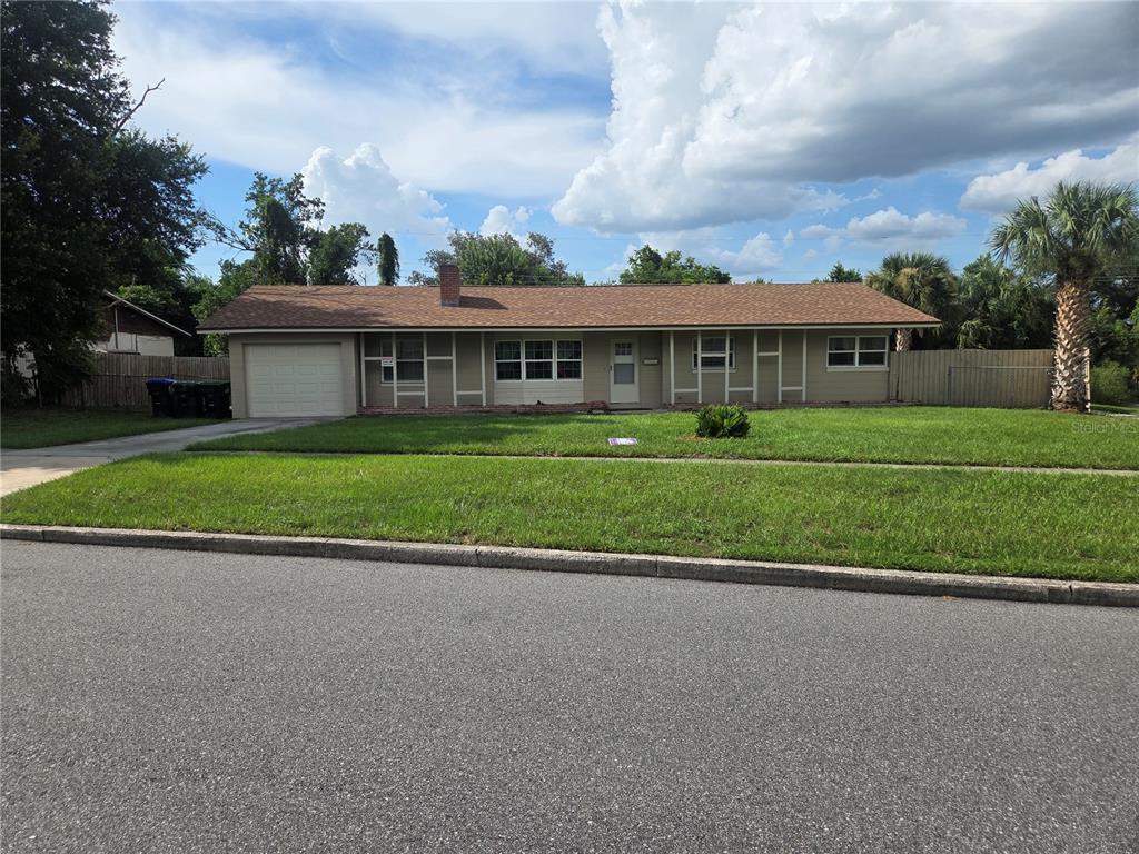 A single-story house with a brown shingled roof, tan siding, and an attached garage — 5903 RIVIERA DRIVE, ORLANDO, FL