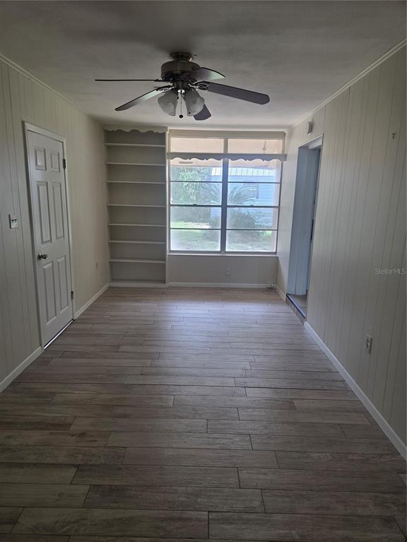 A living room features light wood-look tile flooring, a white brick fireplace, and neutral walls — 5903 RIVIERA DRIVE, ORLANDO, FL
