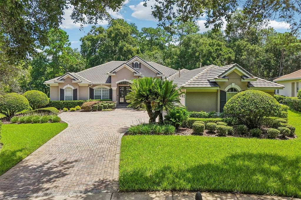 A single-story house with a paved driveway, manicured landscaping, and a tile roof — 3274 OAKMONT TERRACE, LONGWOOD, FL