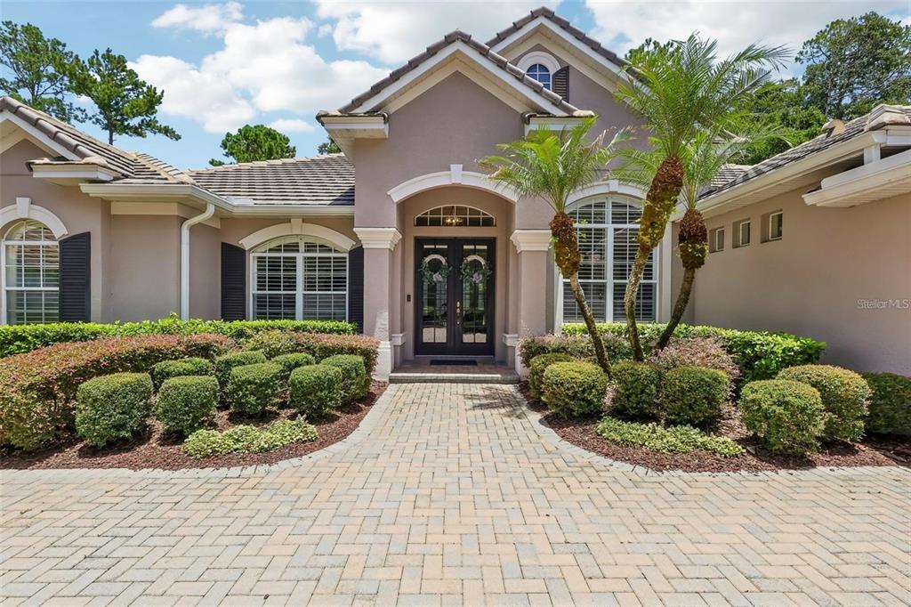 A single-story house with a paved walkway, manicured landscaping, and a double front door entrance — 3274 OAKMONT TERRACE, LONGWOOD, FL