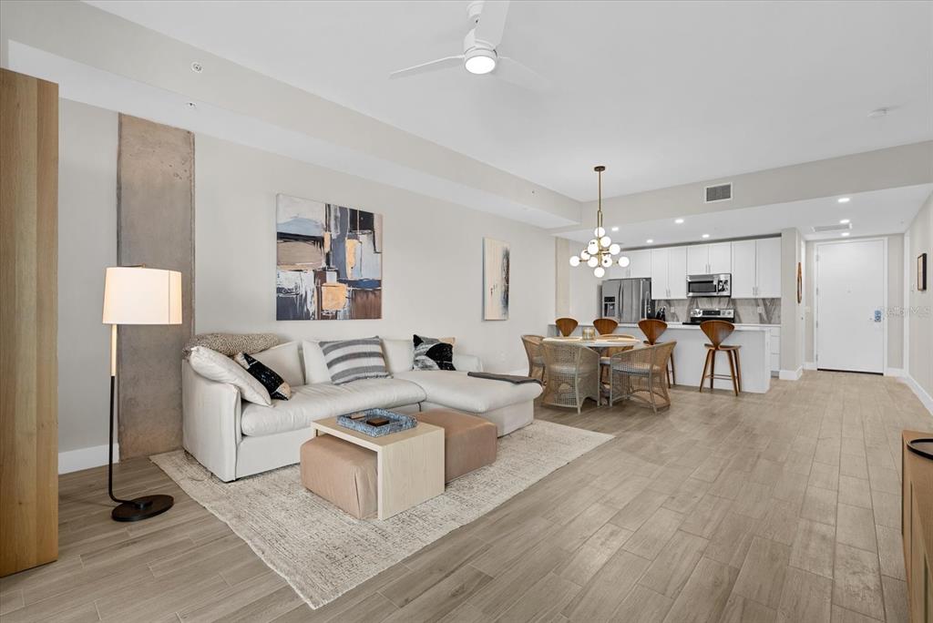 A modern open-concept living and dining area with light wood floors and white cabinetry — 332 COCOANUT AVENUE UNIT 302, SARASOTA, FL