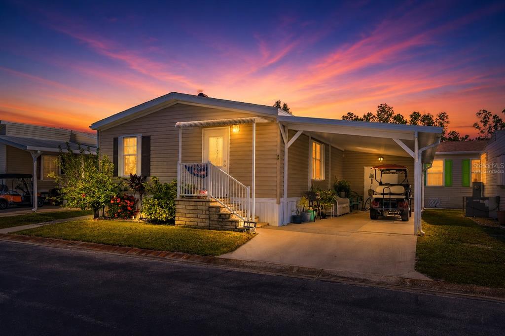 An aerial view shows several manufactured homes with carports and driveways in a residential community — 1000 KINGS HIGHWAY UNIT 54, PORT CHARLOTTE, FL