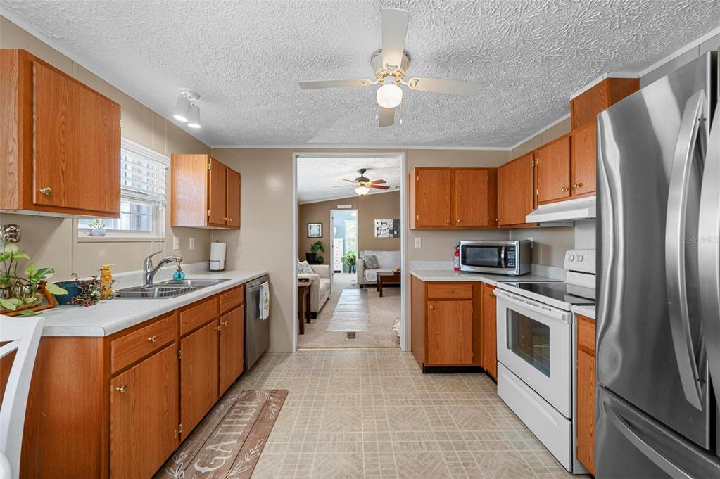 A bedroom with blue walls, a queen bed, white furniture, and a ceiling fan — 1000 KINGS HIGHWAY UNIT 54, PORT CHARLOTTE, FL