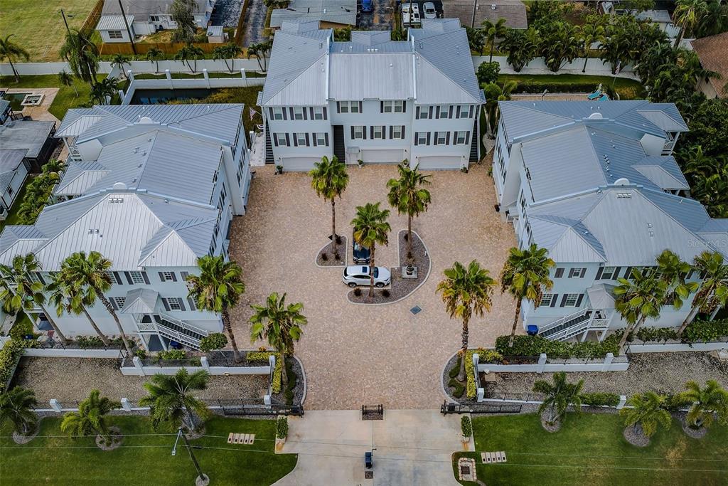 An aerial view of a multi-story blue apartment complex with a swimming pool and palm trees — 7010 GREVILLA AVENUE S, SOUTH PASADENA, FL