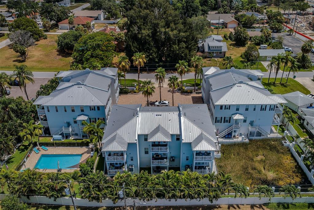 A three-story townhouse with light blue siding, a two-car garage, and a front staircase — 7010 GREVILLA AVENUE S, SOUTH PASADENA, FL