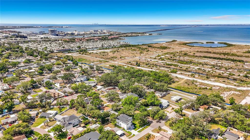 An aerial view shows a residential neighborhood near a large bay and a long bridge — 4732 W WALLCRAFT AVENUE, TAMPA, FL