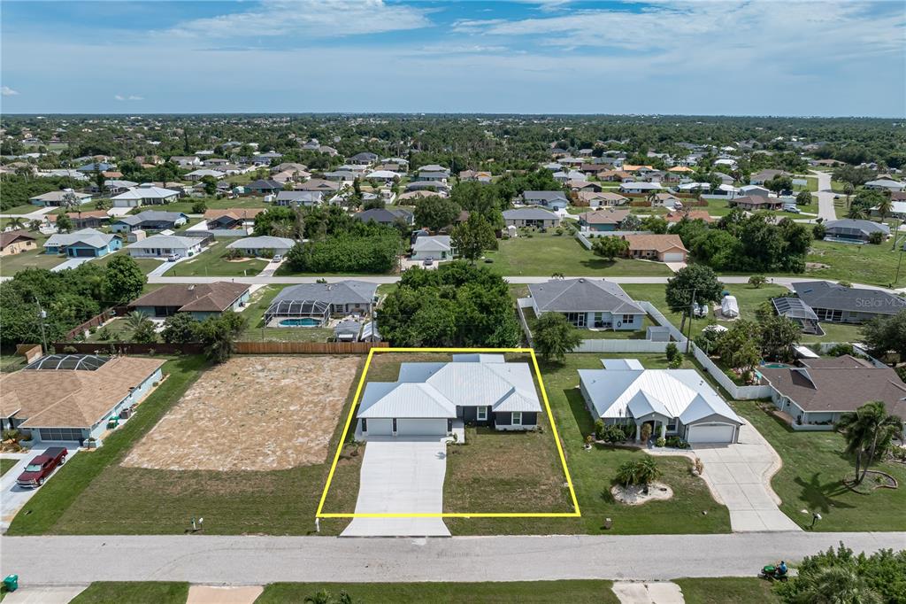 An aerial view shows a single-story house with a white roof and driveway — 9417 HEARTWELLVILLE AVENUE, ENGLEWOOD, FL