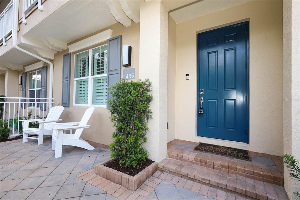 A blue front door and two white chairs sit on a paved patio entrance — 1465 LAKE GEORGE DRIVE, LAKE MARY, FL
