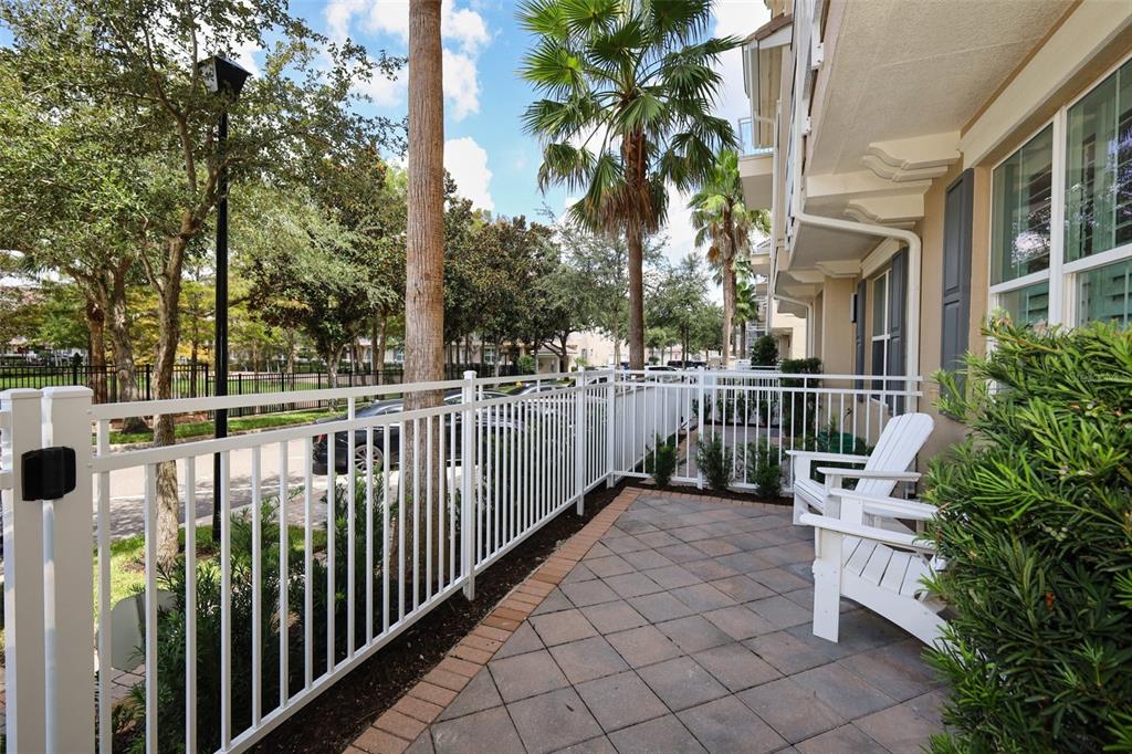 A paved patio with white chairs and a white fence overlooks a parking area — 1465 LAKE GEORGE DRIVE, LAKE MARY, FL