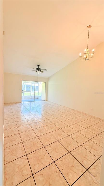 A spacious room with light-colored tile flooring, a ceiling fan, and a chandelier — 3104 LANDSEND COURT, KISSIMMEE, FL