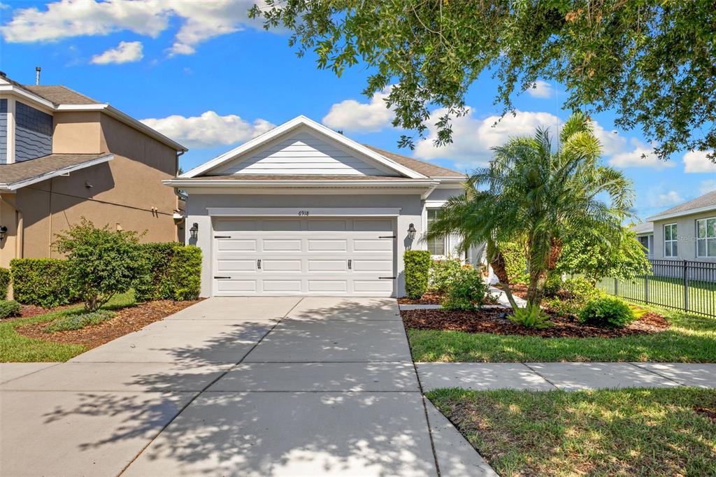 A single-story house with a white garage door, light gray siding, and a concrete driveway — 6918 MAKERS WAY, APOLLO BEACH, FL