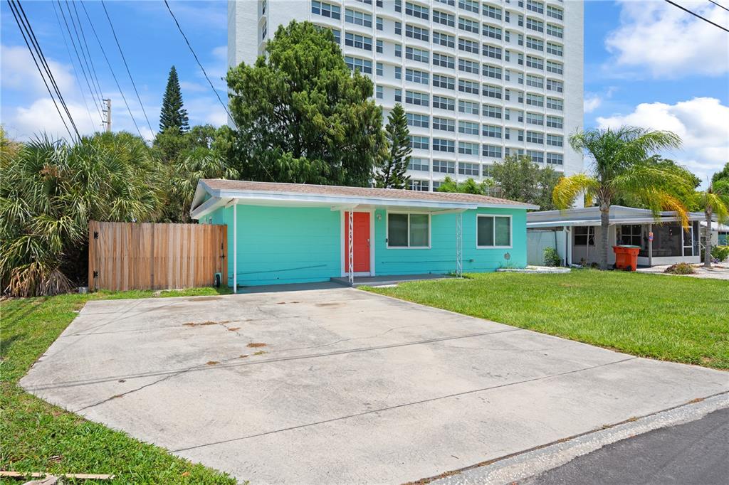 A turquoise single-story house with a red front door and a concrete driveway — 6761 HIBISCUS AVENUE S, SOUTH PASADENA, FL