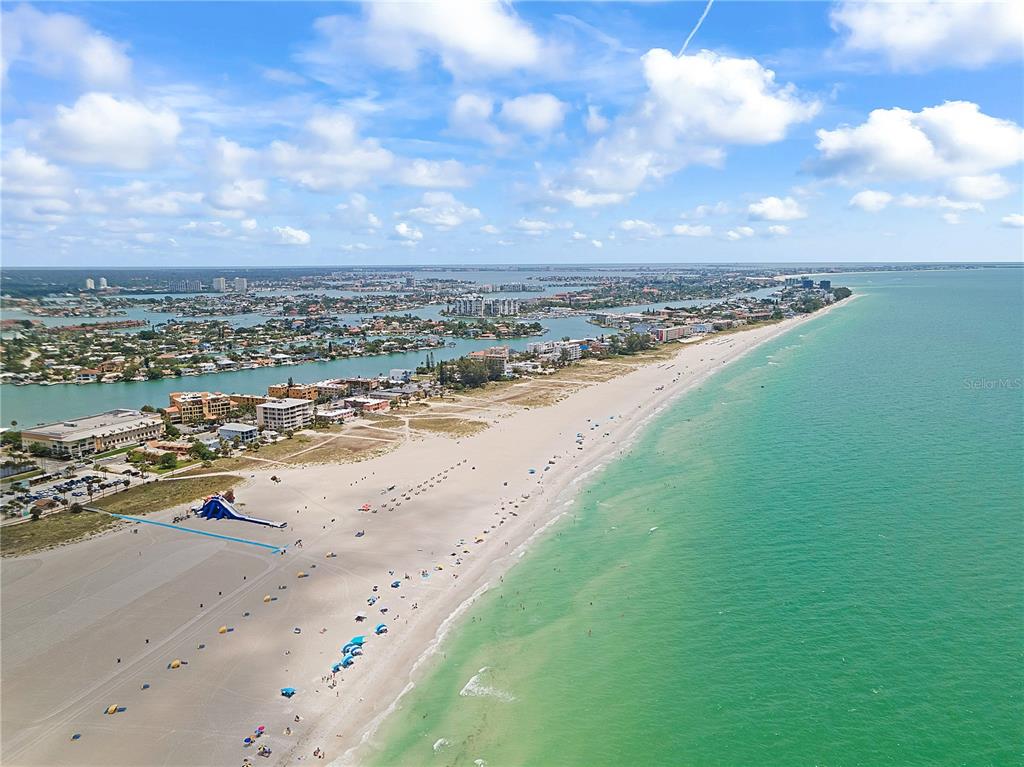 An aerial view shows a sandy beach along the ocean with nearby buildings and waterways — 6761 HIBISCUS AVENUE S, SOUTH PASADENA, FL