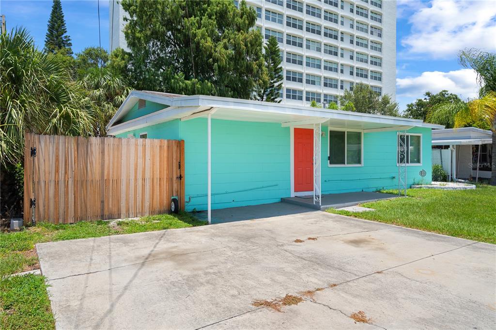 A bright turquoise single-story house with a red front door and a concrete driveway — 6761 HIBISCUS AVENUE S, SOUTH PASADENA, FL