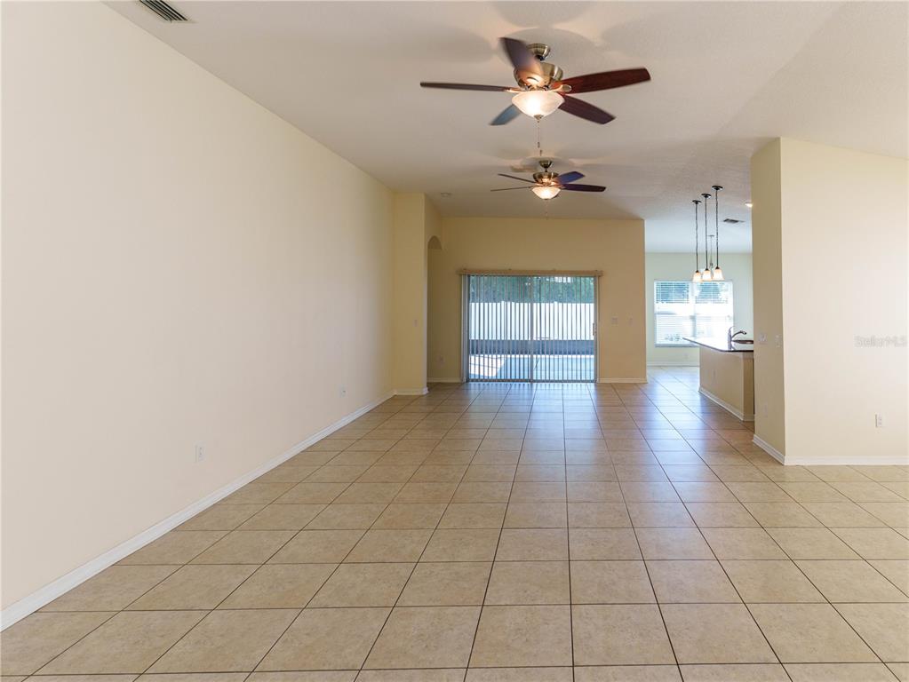 A single-story house with a beige stucco exterior, a two-car garage, and a paved driveway — 14148 FINSBURY DRIVE, SPRING HILL, FL
