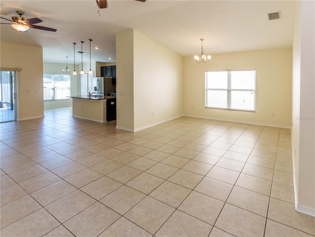 A living room features tile flooring, a large entertainment center, and brown leather reclining furniture — 14148 FINSBURY DRIVE, SPRING HILL, FL