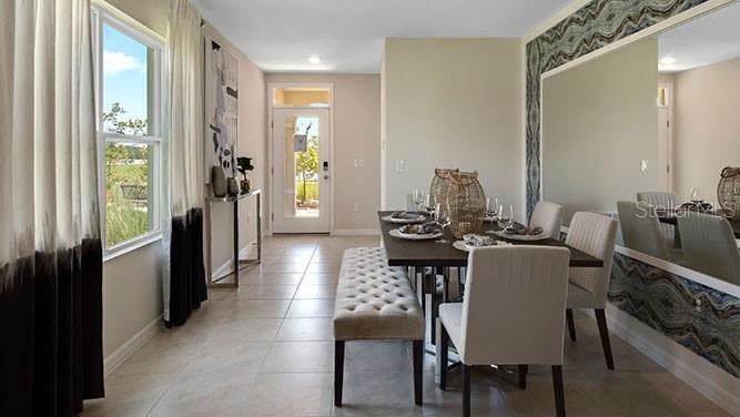 A dining room with a table, chairs, a bench, and a large mirror on the wall — 8310 PONCE DE LEON STREET, LAKELAND, FL