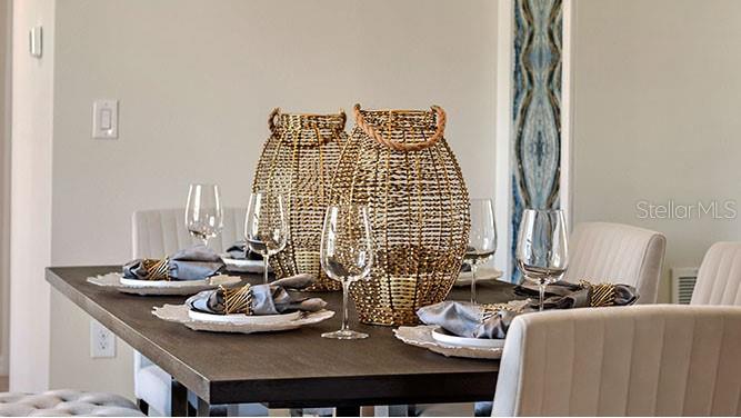 A dining room table is set with wine glasses, napkins, and two decorative gold wire lanterns — 8310 PONCE DE LEON STREET, LAKELAND, FL