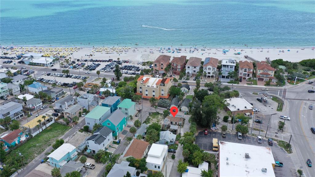 An aerial view shows a coastal town with a beach, waterway, and a red location marker — 101 95TH AVENUE, TREASURE ISLAND, FL