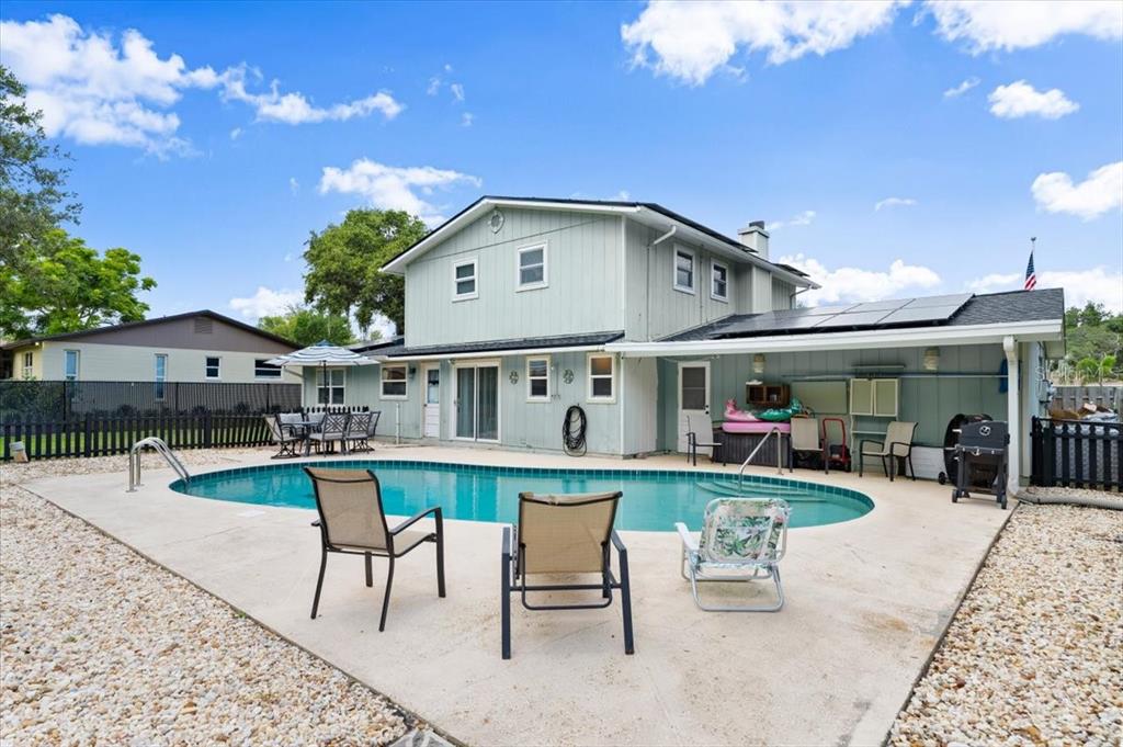 A two-story house with light blue siding features a backyard swimming pool and patio — 20 PUTNAM AVENUE, ORMOND BEACH, FL