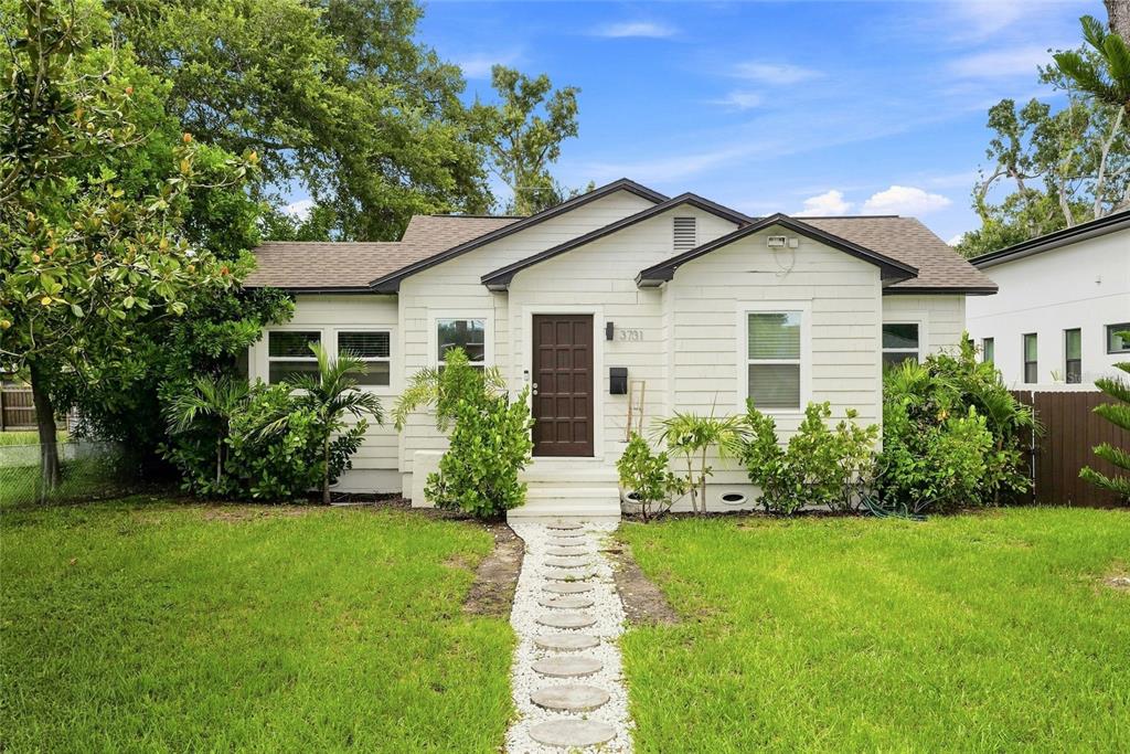 A one-story house with white siding, a dark brown front door, and a stone walkway — 3731 6TH AVENUE N, ST PETERSBURG, FL