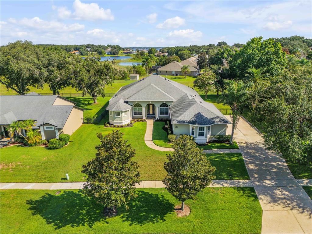 An aerial view shows a single-story house with a gray roof, lawn, and driveway — 10749 ASTATULA LANE, CLERMONT, FL
