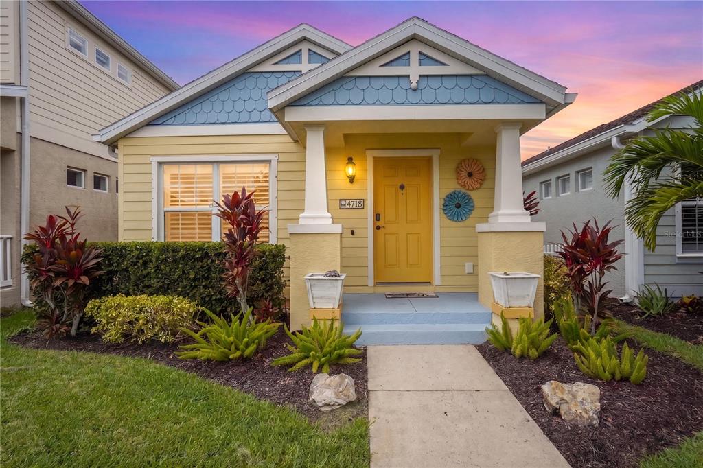 A yellow single-story house with a blue gable, front porch, and a yellow front door — 4718 FOREST CREEK TRAIL, PARRISH, FL
