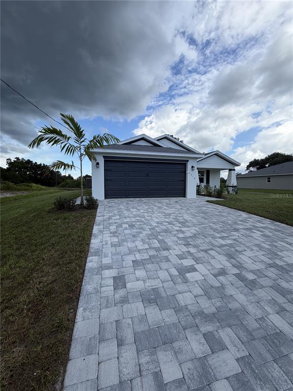 A single-story suburban house with a gray garage, paved driveway, and a covered front porch — 6316 DEER RUN RD, NORTH PORT, FL
