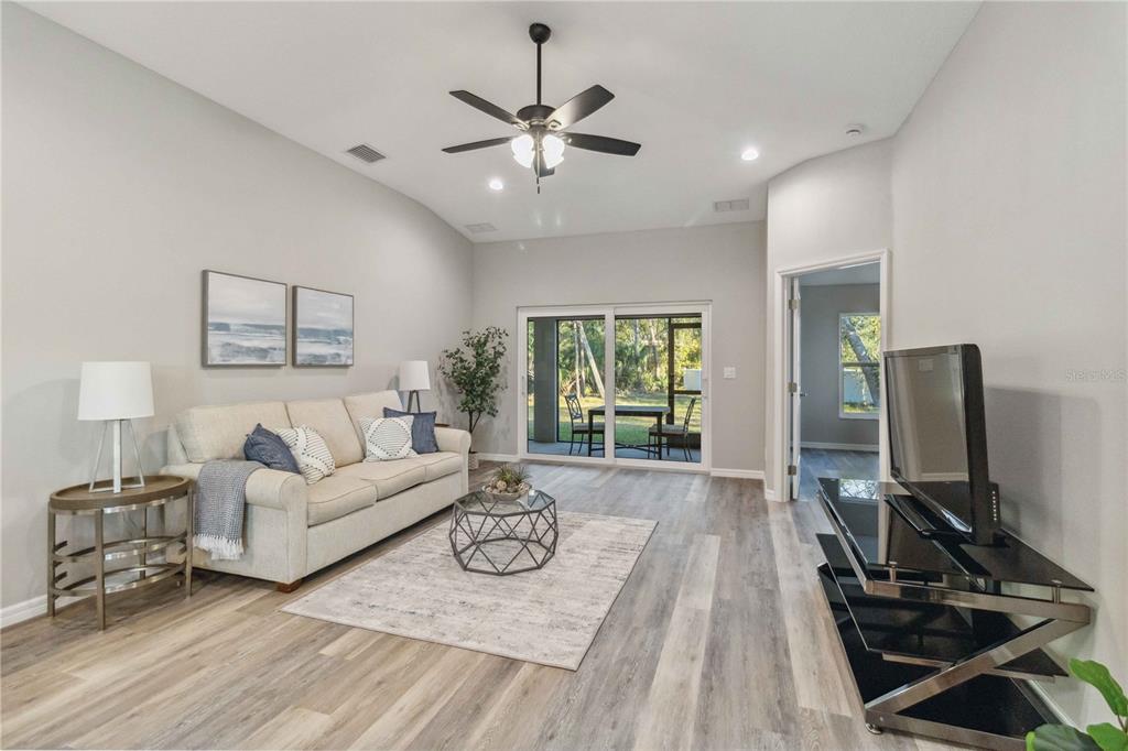 An entryway features a white door, light gray walls, wood-look flooring, and a pendant light — 6316 DEER RUN RD, NORTH PORT, FL