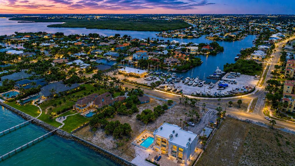 An aerial view of a waterfront property with a pool, dock, and nearby marina — 6504 SURFSIDE BOULEVARD UNIT 8, APOLLO BEACH, FL