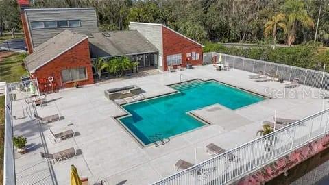 An aerial view shows a rectangular swimming pool with a surrounding patio and brick building — 9100 DR MARTIN LUTHER KING JR STREET N UNIT 1707, ST PETERSBURG, FL