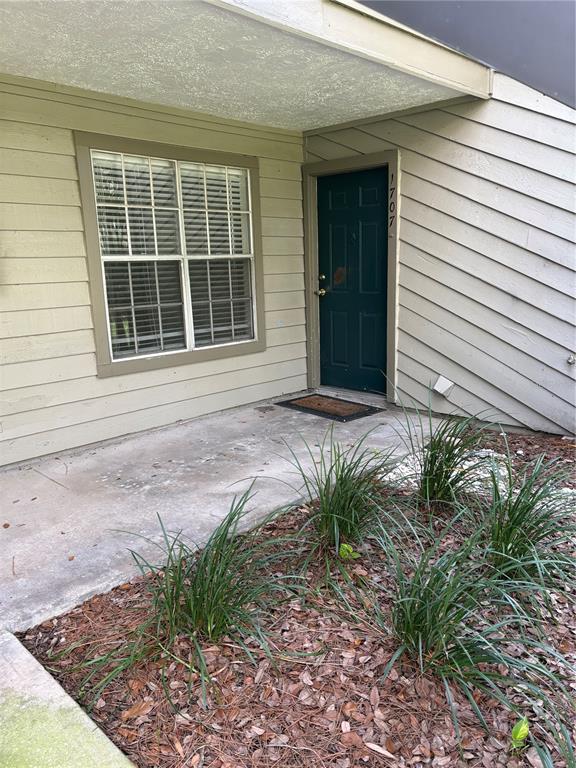 A dark green front door and a window with blinds are set in a beige exterior — 9100 DR MARTIN LUTHER KING JR STREET N UNIT 1707, ST PETERSBURG, FL