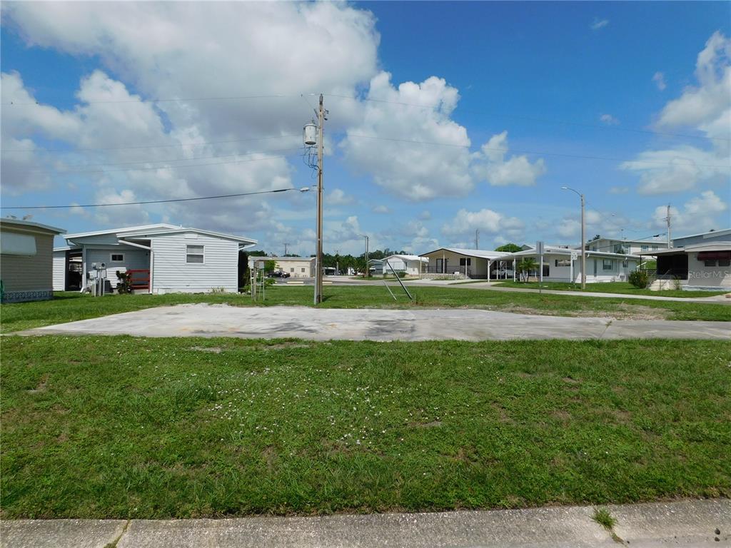 A vacant concrete pad sits on a grassy lot in a mobile home community — 1205 43RD AVENUE DRIVE E, ELLENTON, FL