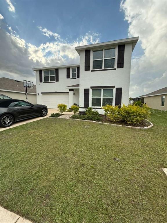 A two-story white house with dark shutters and a front-facing garage — 10662 CHIPPEWA DRIVE, PARRISH, FL