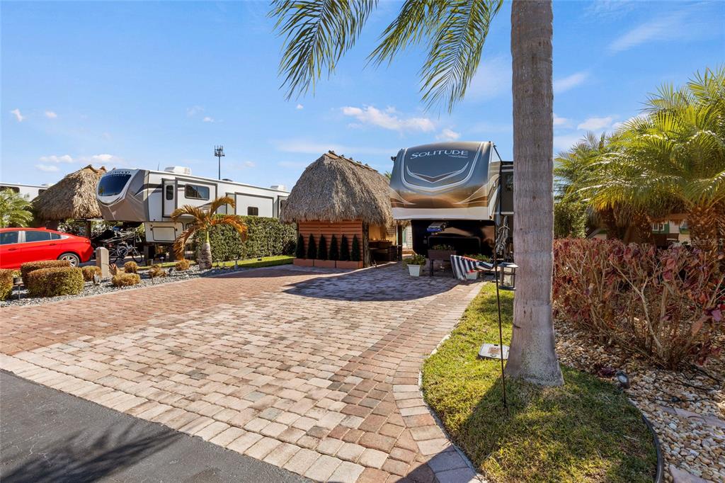 A paved driveway leads to two parked RVs and a tiki hut under palm trees — 532 SW 38TH TRACE, OKEECHOBEE, FL