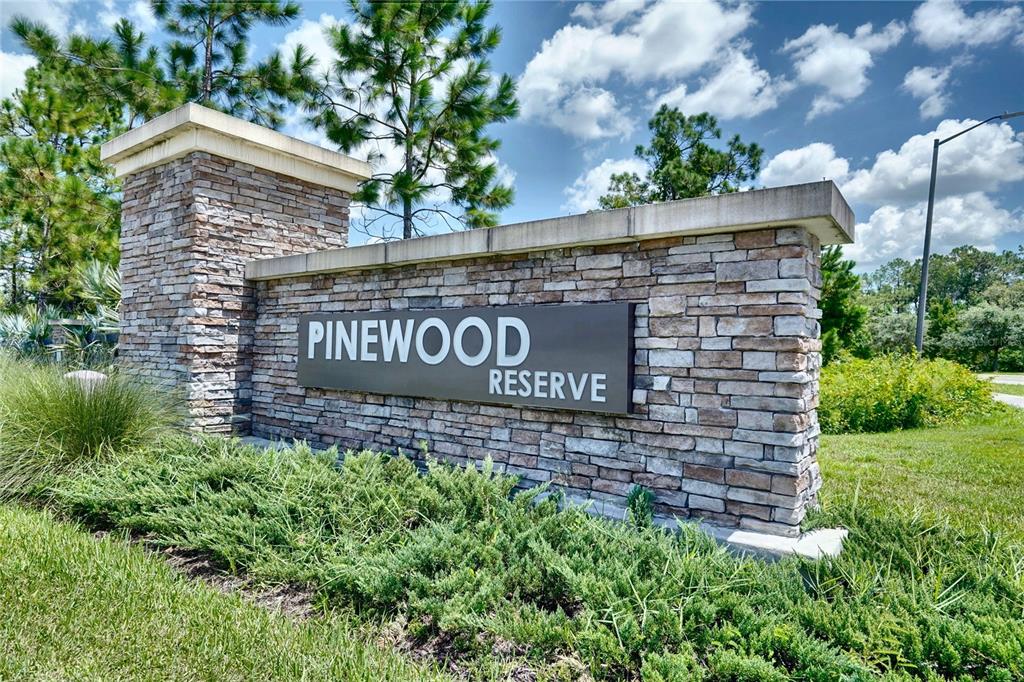 The exterior of a house features a gray garage door, stone accents, and a front entrance — 6030 ARBOR WATCH LOOP, ORLANDO, FL