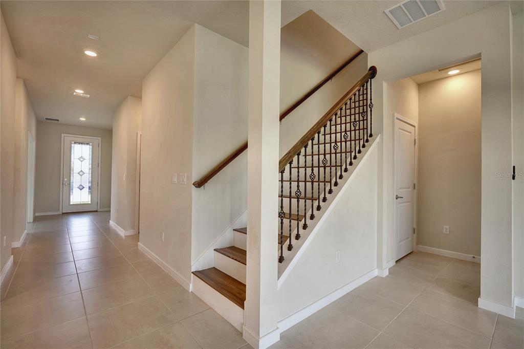 A modern kitchen features white cabinetry, stainless steel appliances, a quartz island, and pendant lighting — 6030 ARBOR WATCH LOOP, ORLANDO, FL