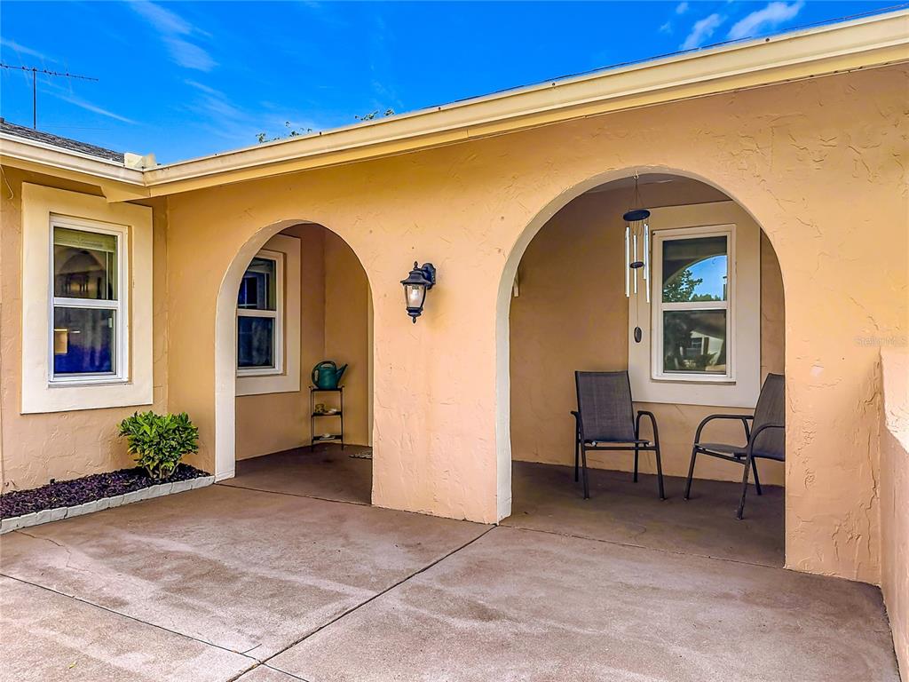 A single-story pink house with a two-car garage and a large tree in the yard — 5020 THE OAKS CIRCLE, ORLANDO, FL