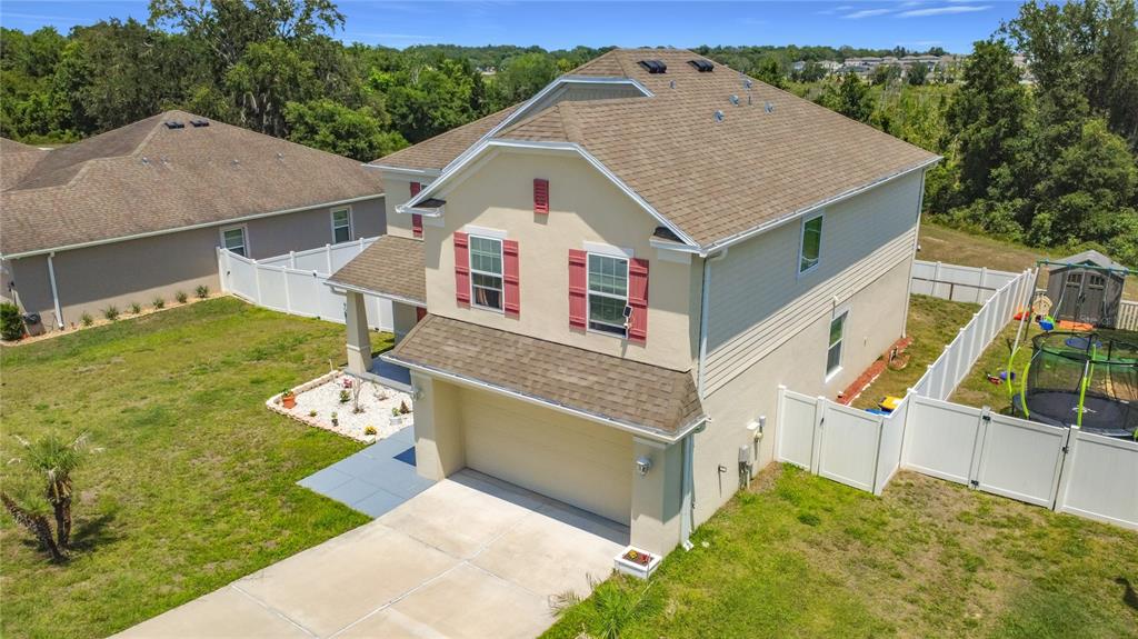 An aerial view of a two-story suburban house with a tan exterior and brown roof — 15523 GEMINI DRIVE, MASCOTTE, FL