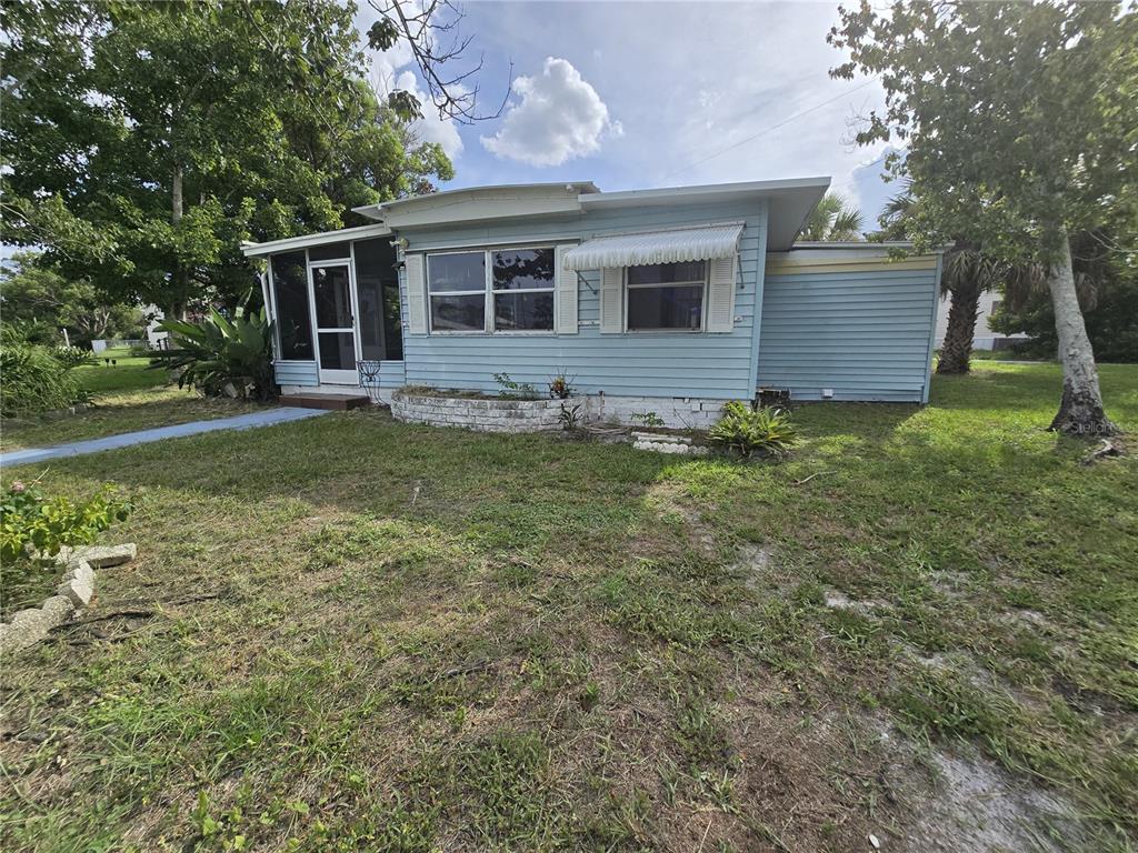 A light blue single-story house with a screened porch and a white brick planter — 5414 TAYLOR AVENUE, PORT ORANGE, FL