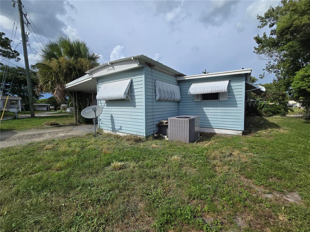 A light blue mobile home with metal awnings and an outdoor air conditioning unit — 5414 TAYLOR AVENUE, PORT ORANGE, FL