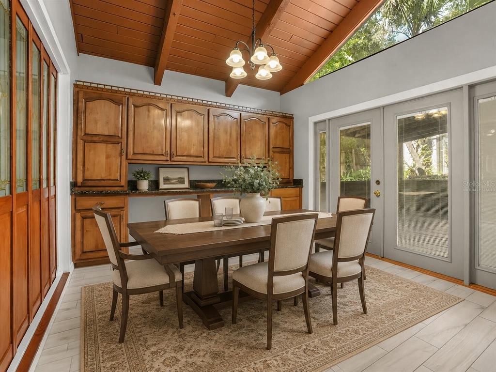 A dining room features a vaulted wood-beam ceiling, wooden cabinetry, and a table with chairs — 280 HUNTERS POINT TRAIL, LONGWOOD, FL