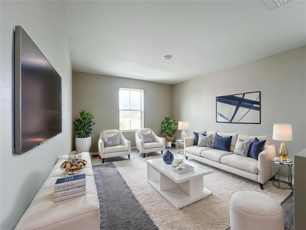 A living room features a white sofa, two armchairs, a coffee table, and a wall-mounted television — 1404 AXEL CIRCLE, WINTER HAVEN, FL
