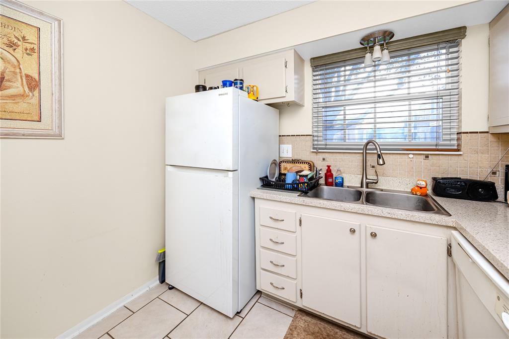 A living room features a red patterned rug, leather seating, and a television on a stand — 3435 41ST TERRACE S UNIT 198, ST PETERSBURG, FL