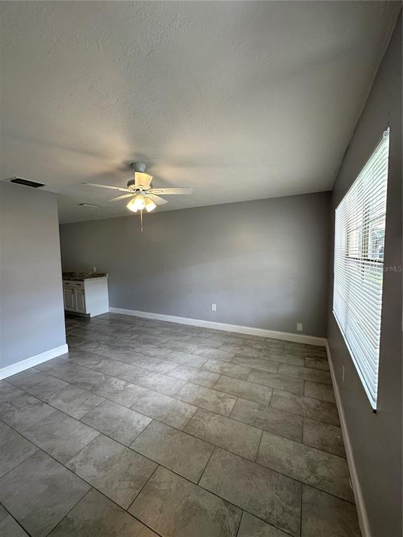 A room with gray walls, tile flooring, a window with blinds, and a white door — 473 93RD AVENUE N, ST PETERSBURG, FL