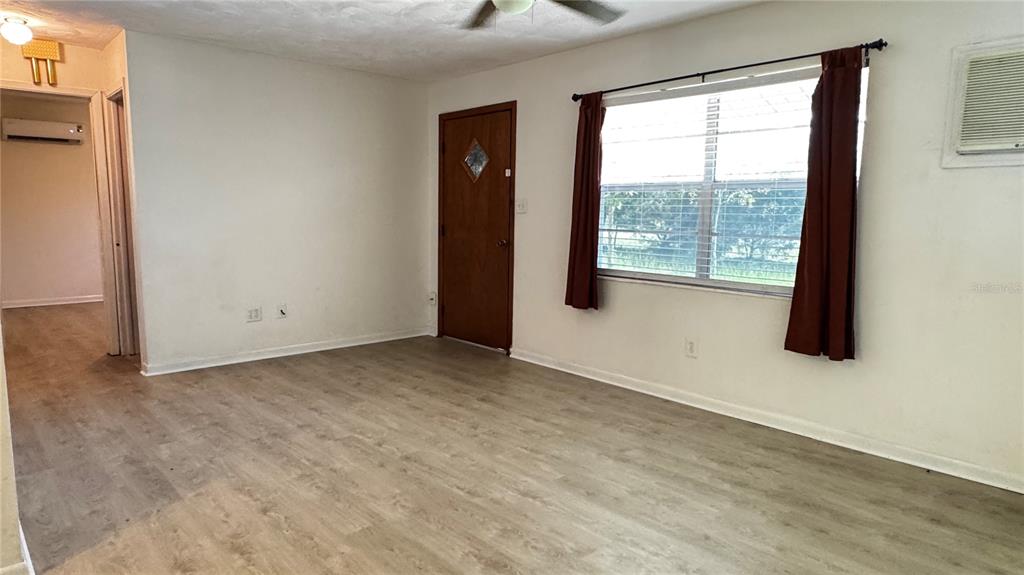 A living room with beige carpet, a ceiling fan, and doorways leading to other rooms — 4316 SW DEEPWATER COURT, DUNNELLON, FL