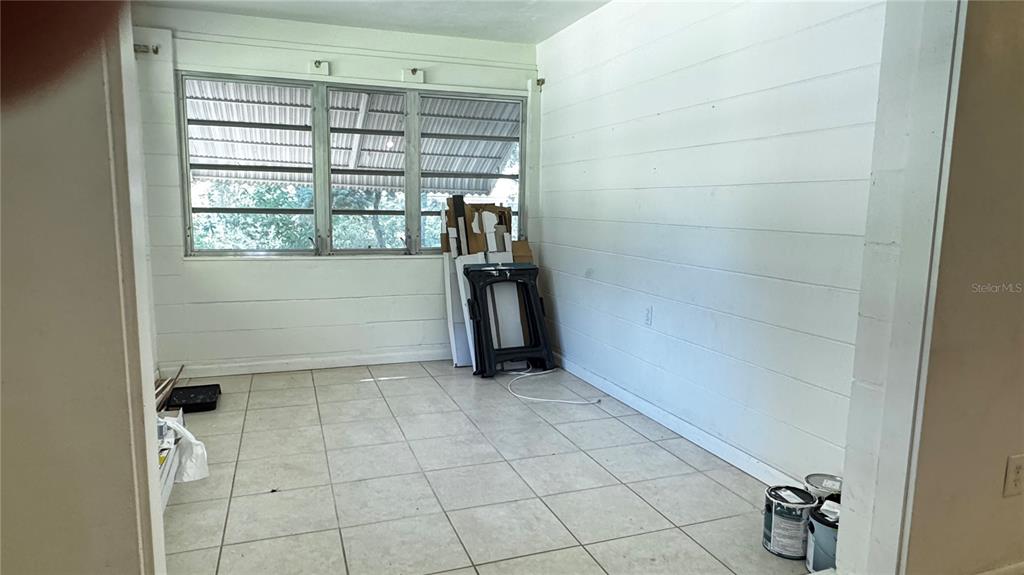 A kitchen with wooden cabinets, black appliances, and a light-colored floor next to a door — 4316 SW DEEPWATER COURT, DUNNELLON, FL