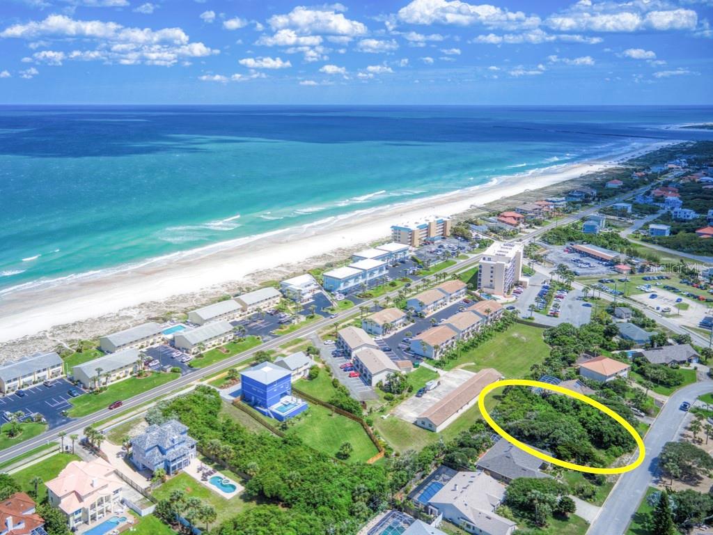 An aerial view of a coastal neighborhood featuring a vacant, tree-covered lot circled in yellow — 62 BUSCHMAN DRIVE, PONCE INLET, FL