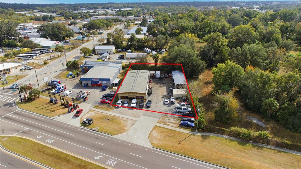 An aerial view shows a commercial property with a warehouse building and parking lot — 212 NW 20TH STREET, OCALA, FL